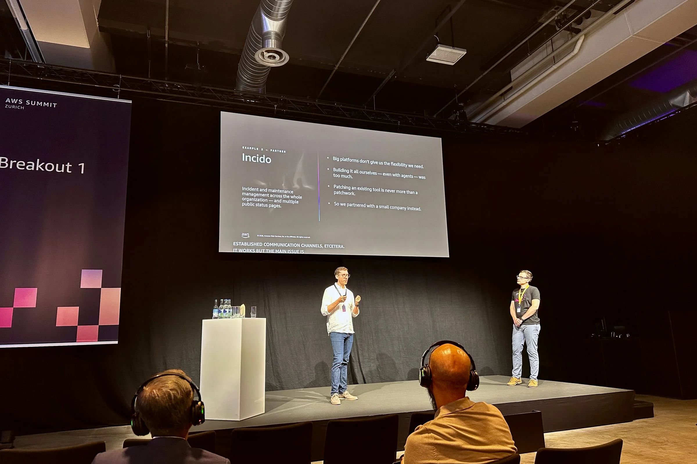 Wallee presenting on stage at AWS Summit Zurich, with the Incido slide visible behind the speakers.